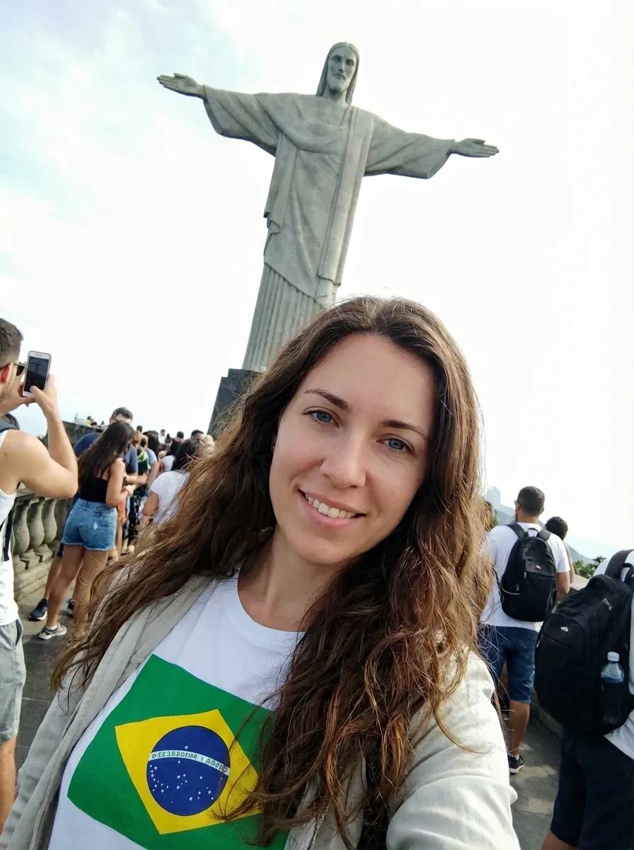 Original selfie input — woman in a white top holding a Brazil flag outdoors